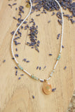 White and blue beaded necklace with pendant